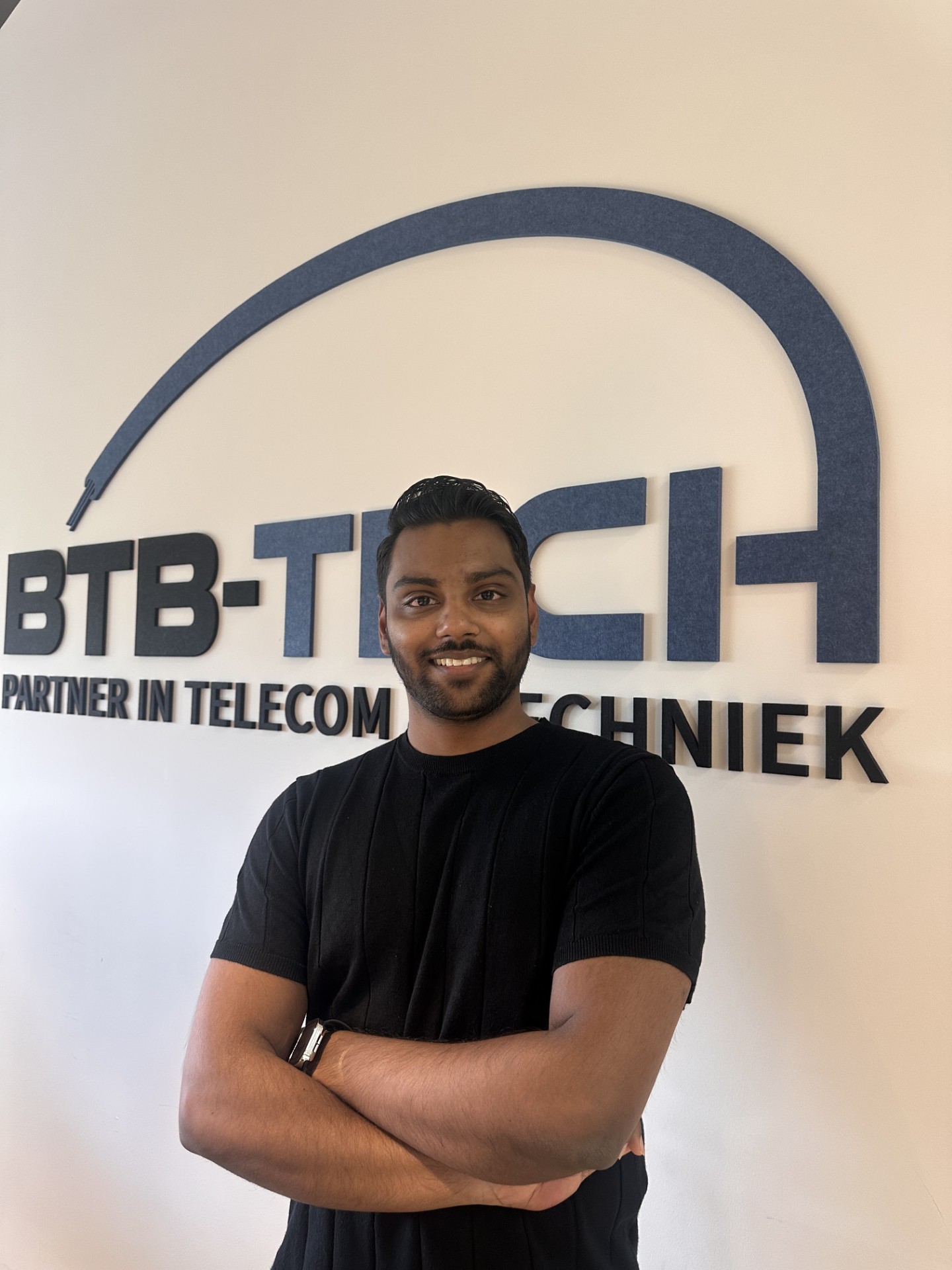 Vijay Gopie, Senior Engineer & Vergunningen bij BTB-Tech, voor de logowand op het hoofdkantoor
