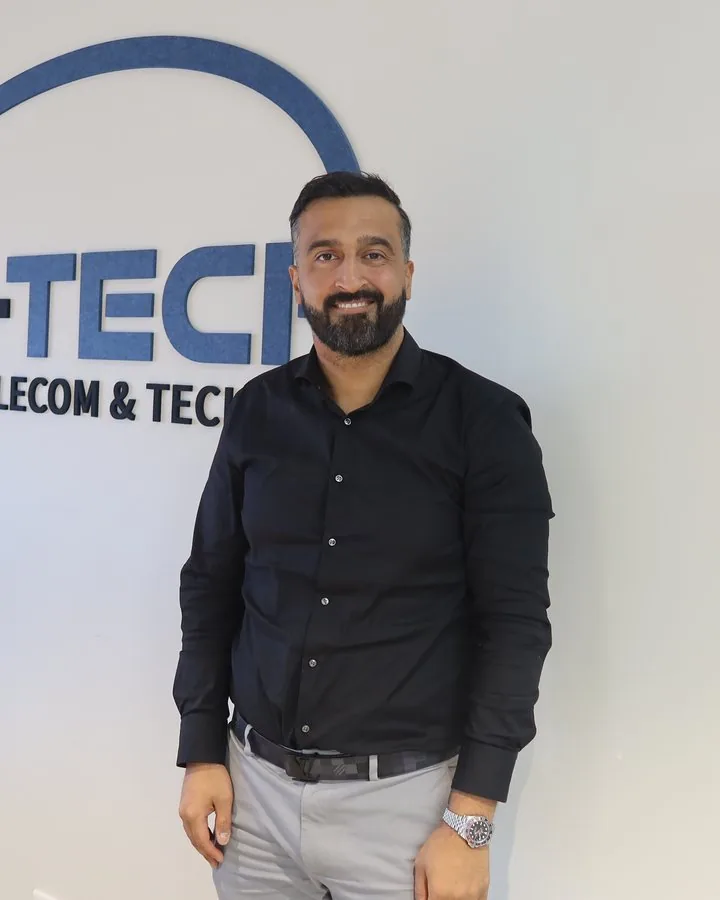 Hussain Almushat, directeur van BTB-Tech, voor de logowand op het hoofdkantoor