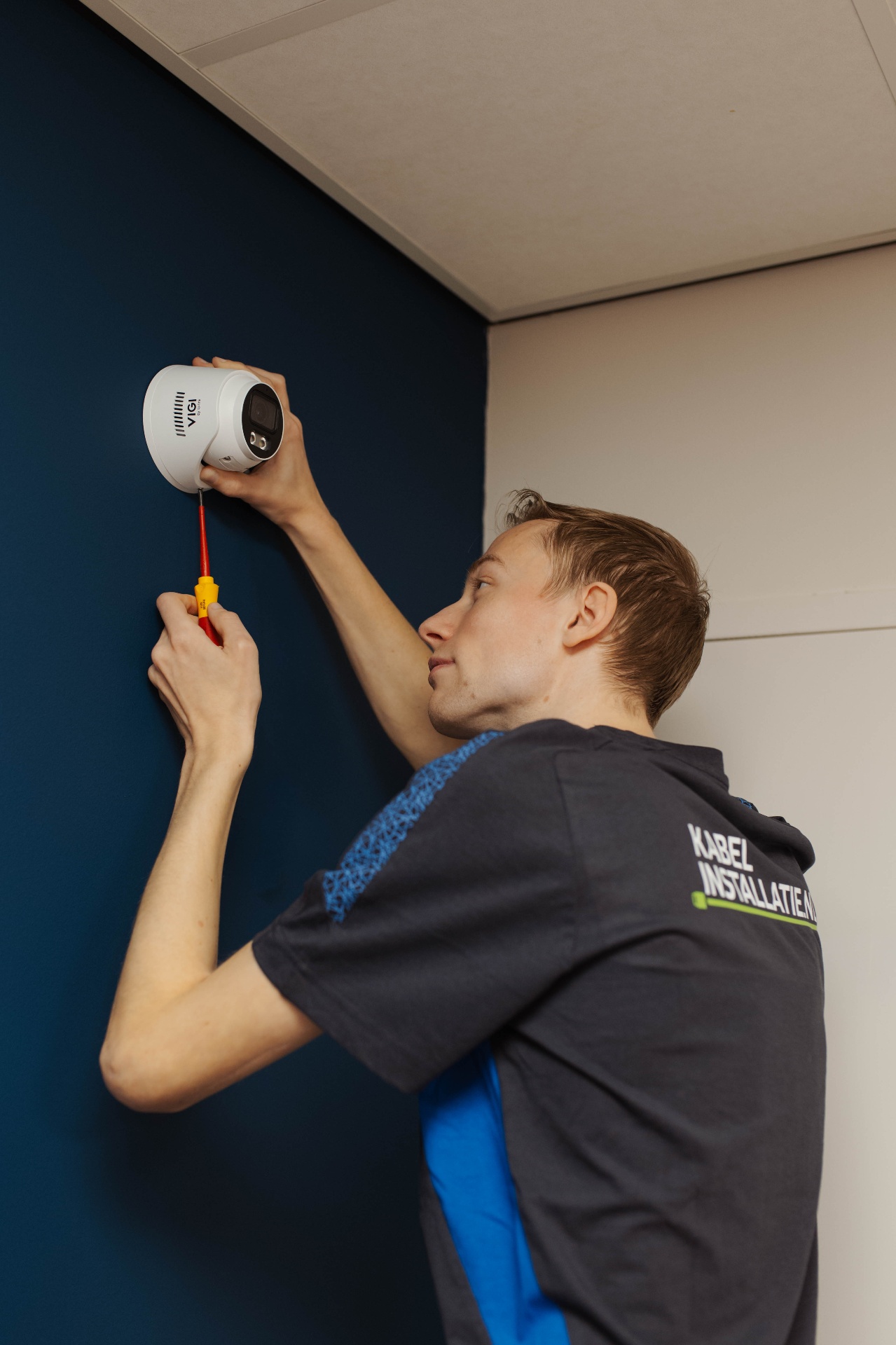 Monteur monteert een beveiligingscamera aan de wand