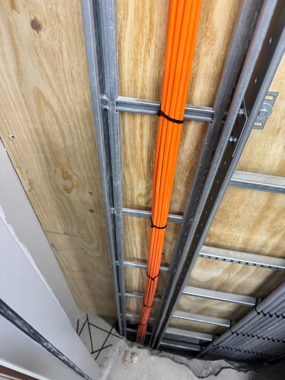 Glasvezelbuizen strak gebundeld op kabelbaan langs het plafond