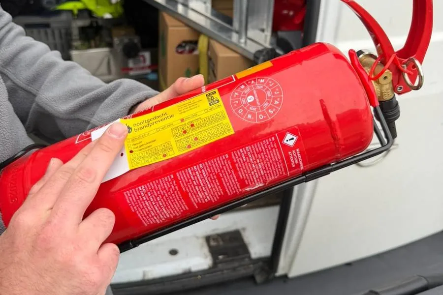 Brandblusser wordt gecontroleerd en gekeurd tijdens de kwartaalkeuring bij de servicebus