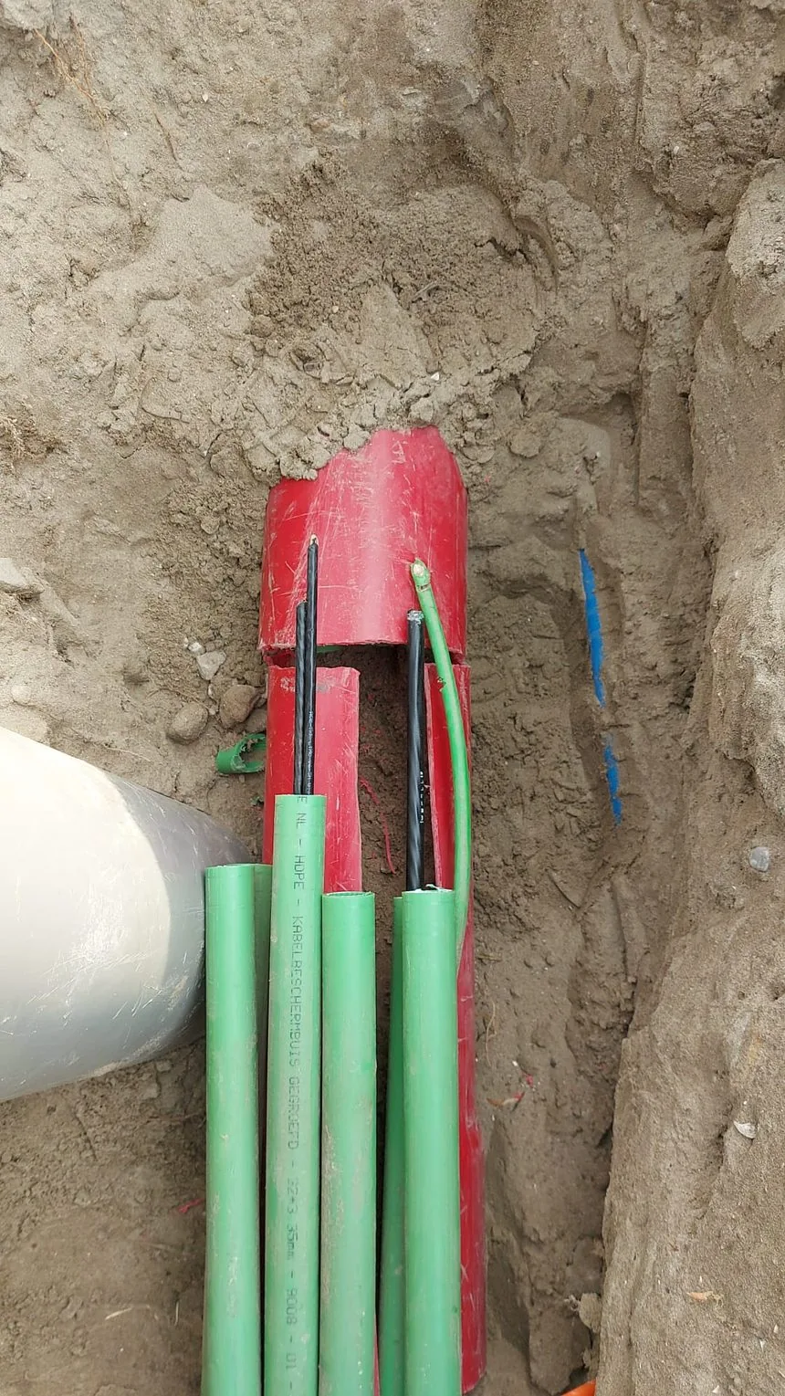 Doorgezaagde mantelbuis met HDPE-buizen en doorgenomen kabels van een ringverbinding in Rotterdam