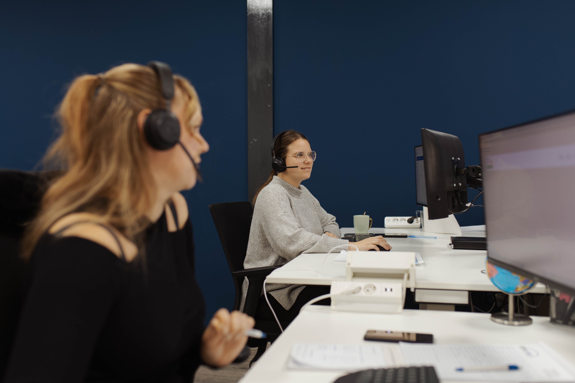 Twee planners aan het werk op kantoor met headsets